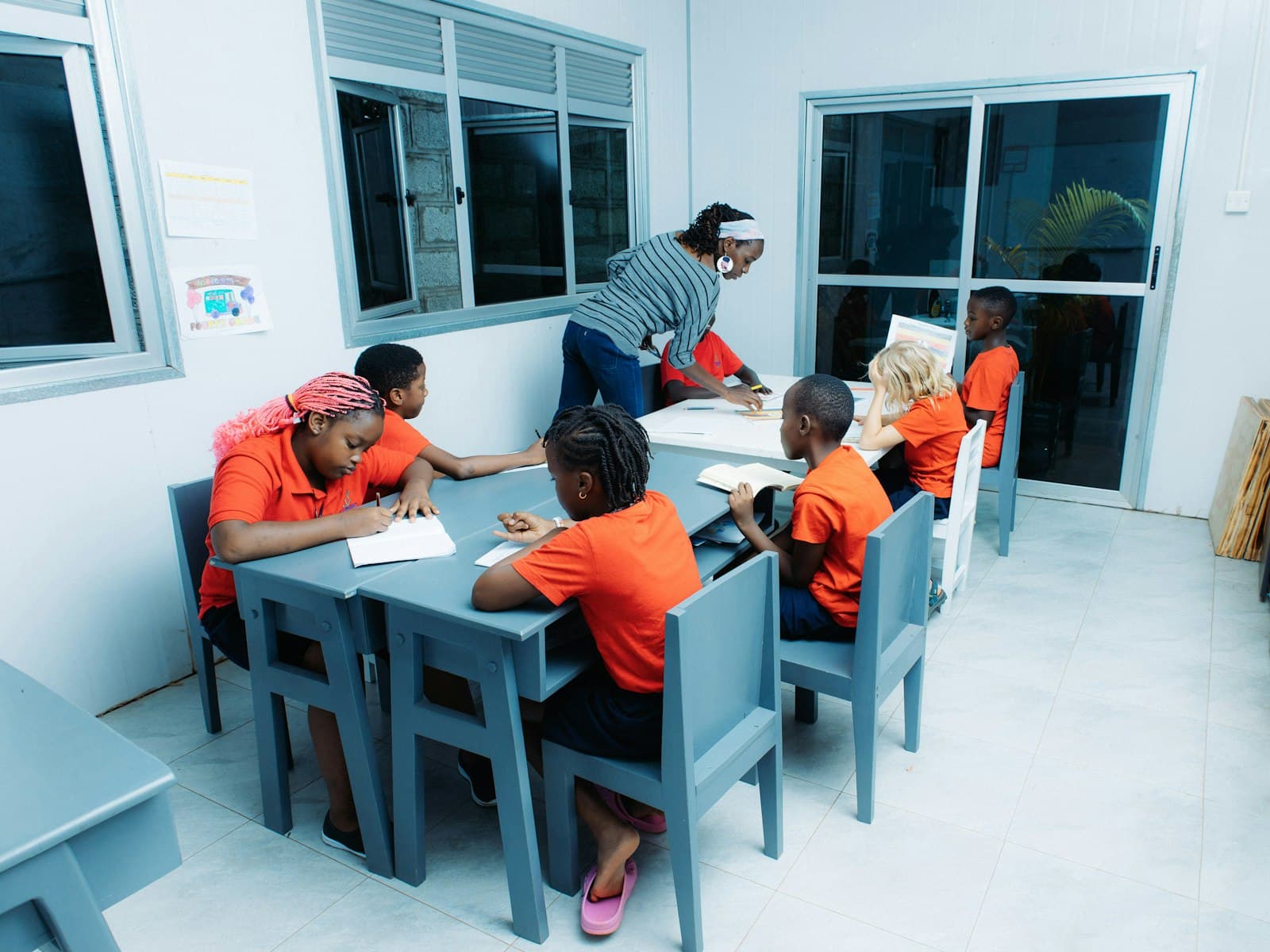 A teacher working with children at their classroom tables