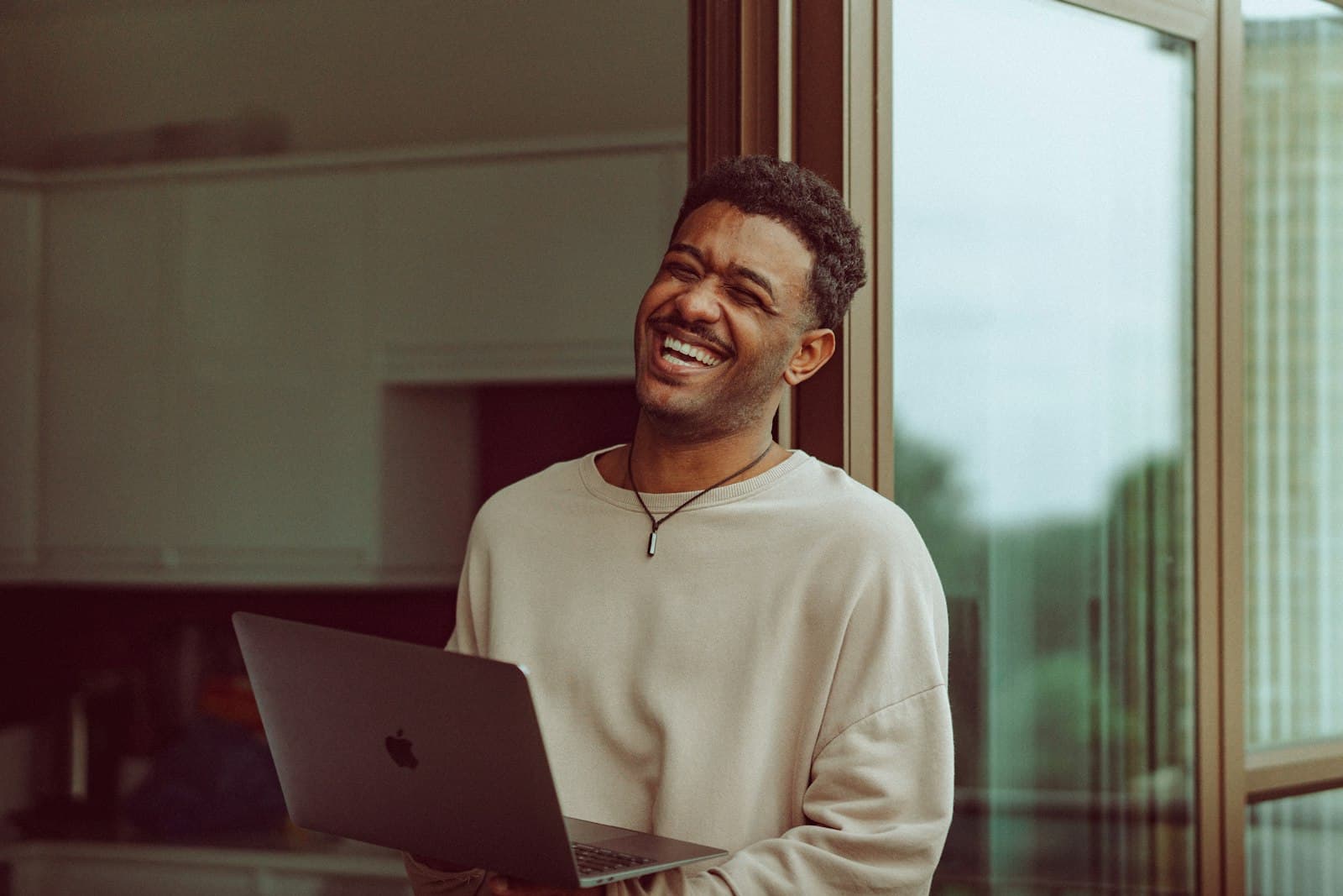 A man smiling at his laptop