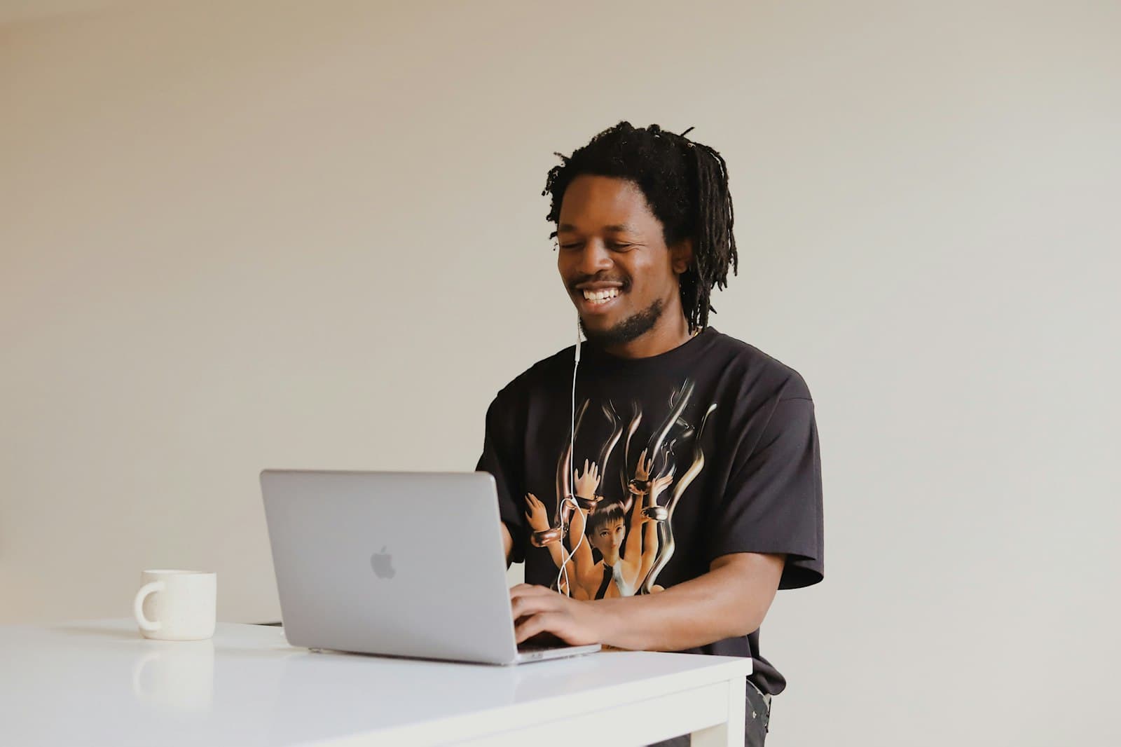A man smiling as he works on his laptop