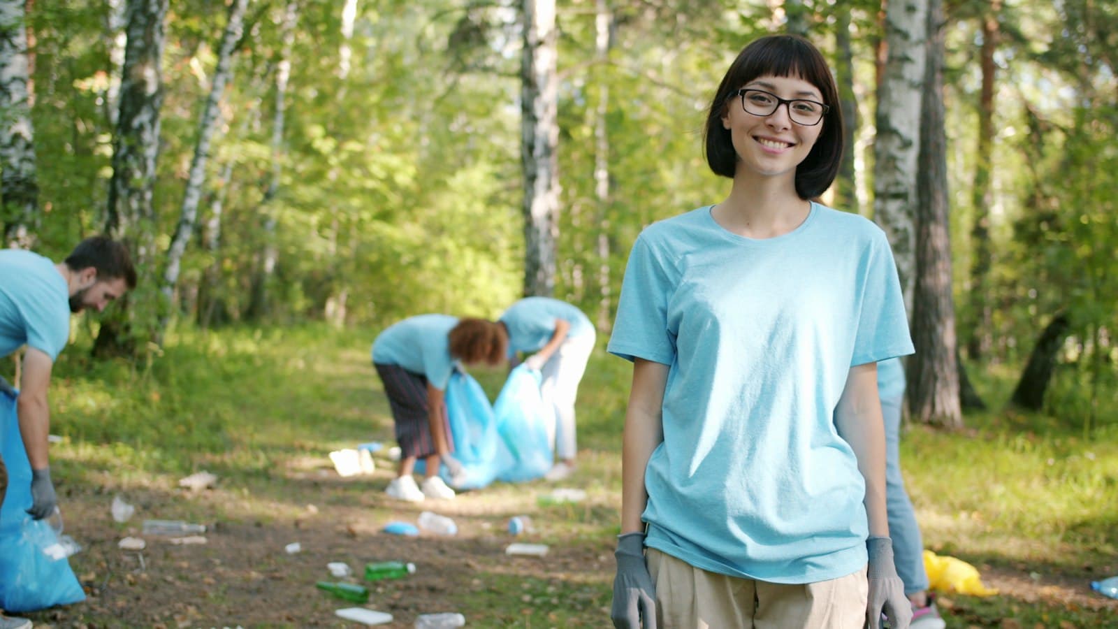 A volunteer smiling during a forest clean-up